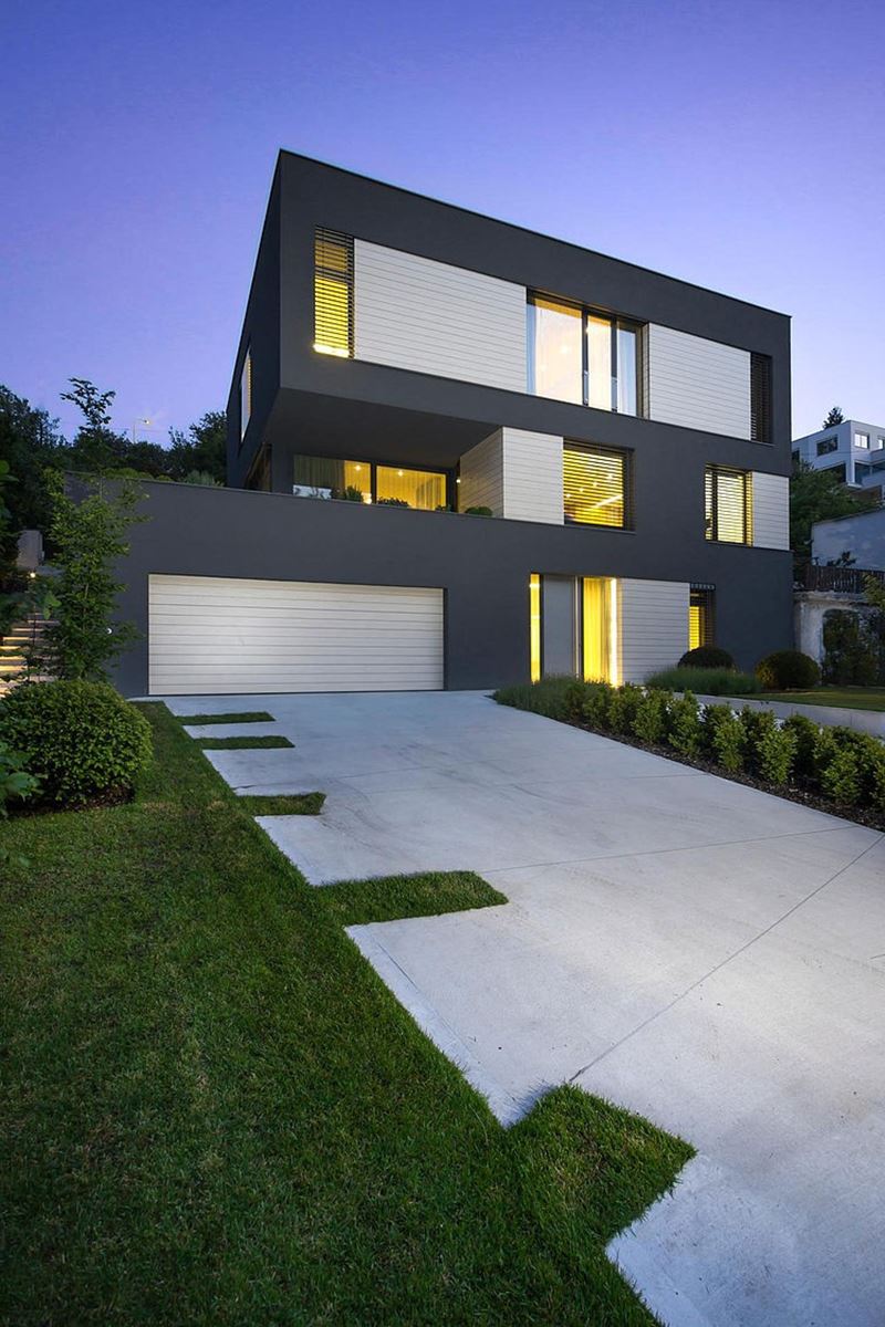 This modern three-story house - neatly trimmed bushes, wide footpath and an entrance to the garage