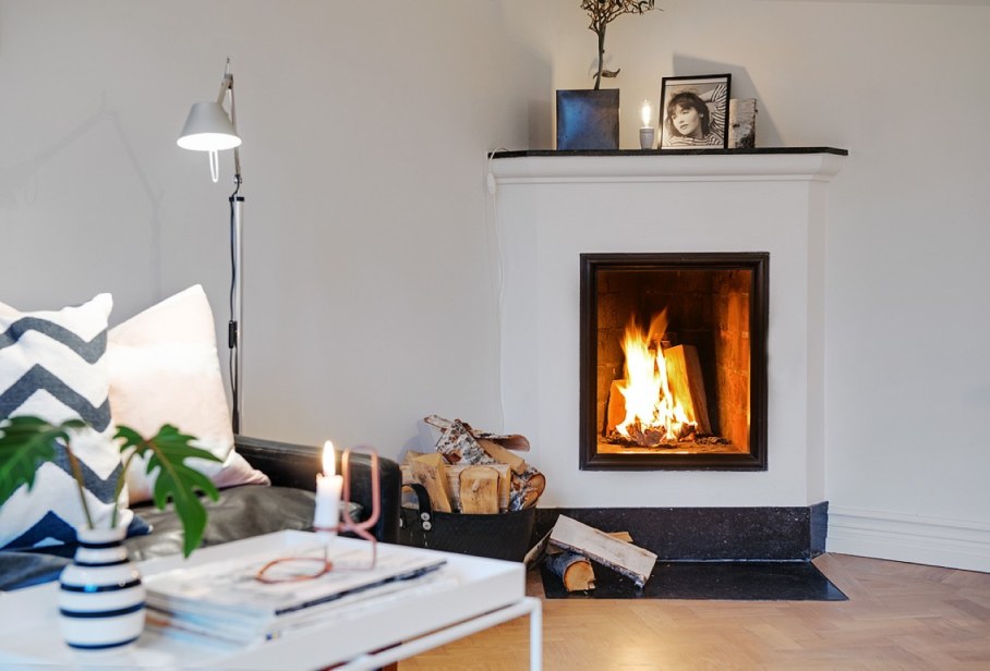 Decorate the zone around the fireplace - firewood candles and pictures in simple framework